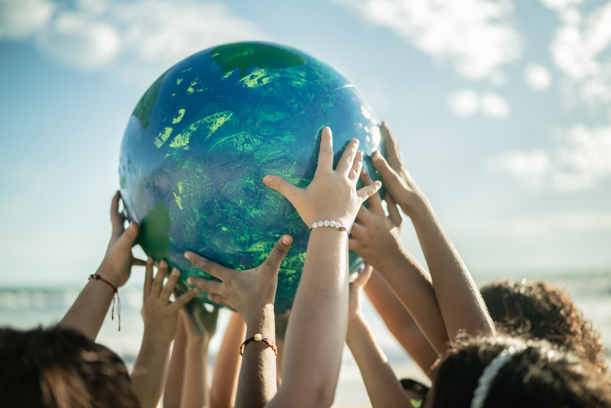Kids hands holding the earth globe together