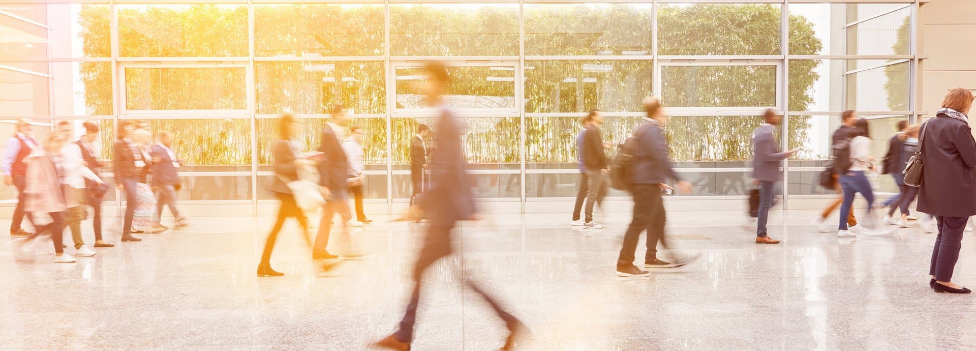 people walking in a bright office alike environment