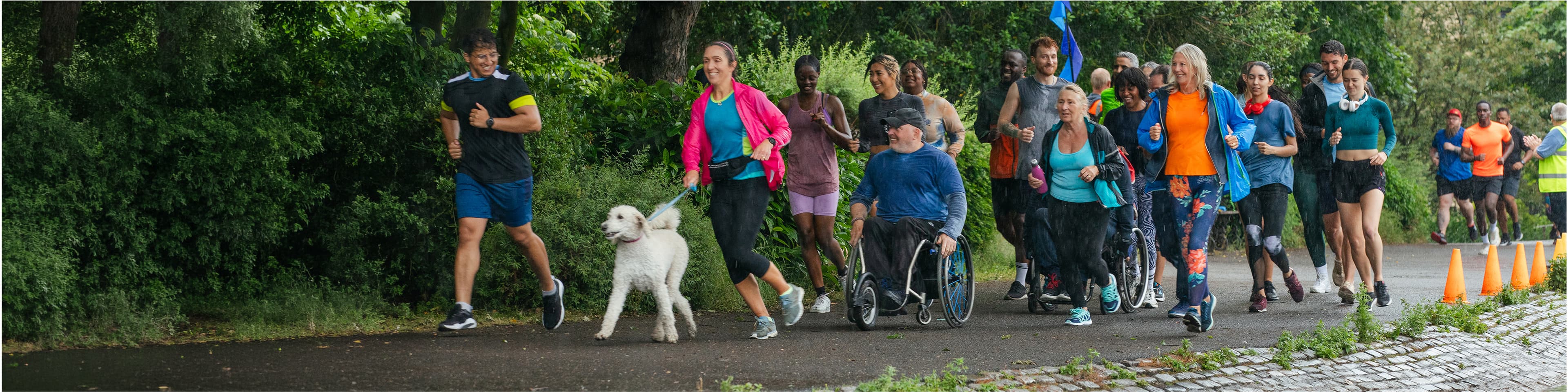 People running in a marathon along with people on a wheelchair