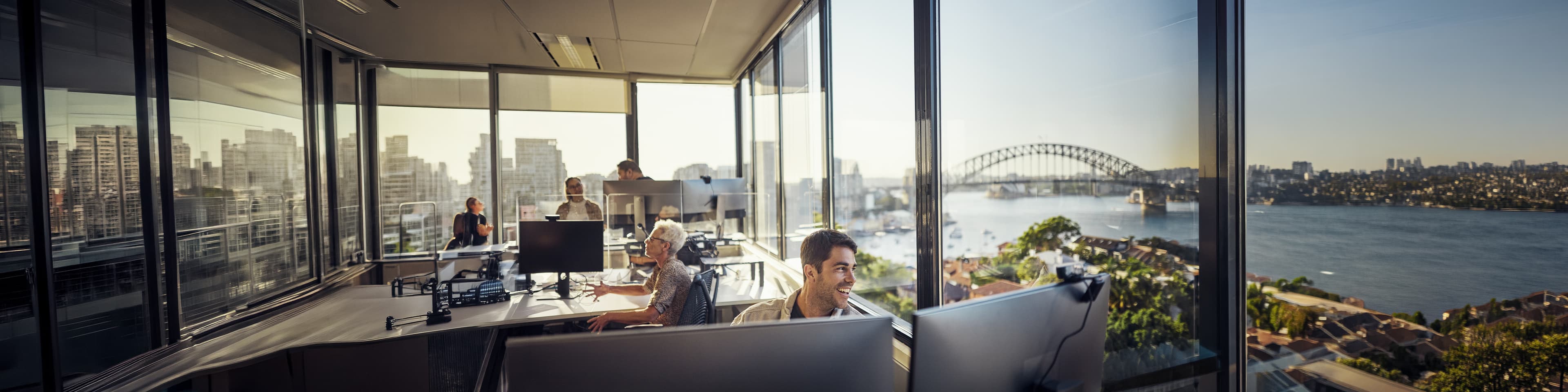 Man working at his desk in the office with a view on one of the Australians city skylines