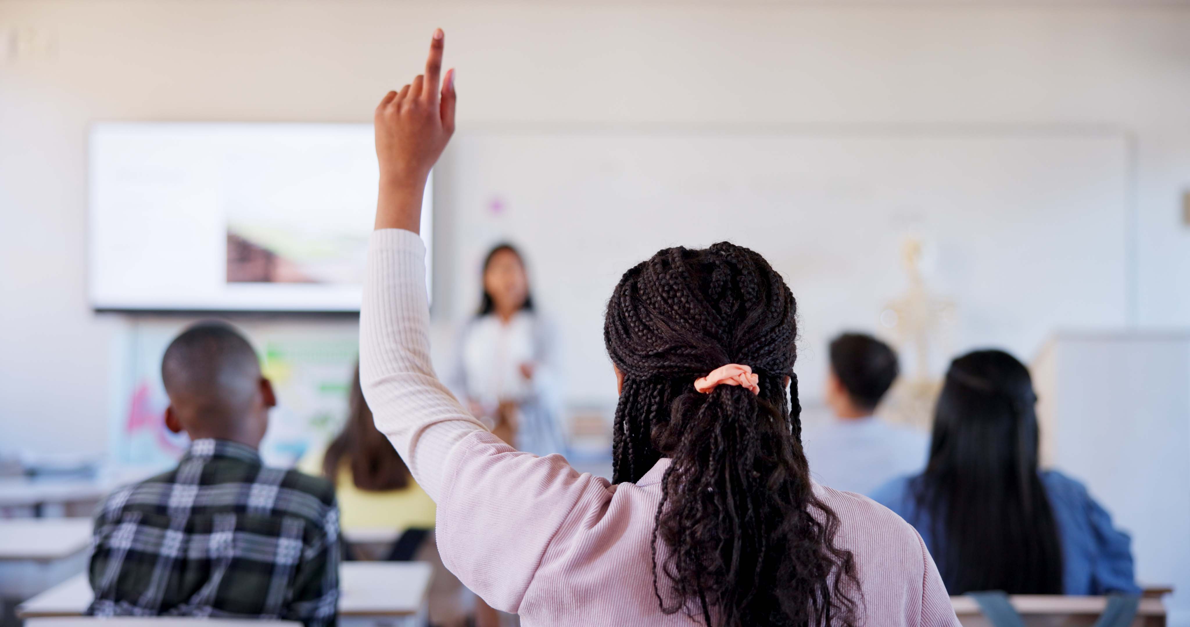 Dark sking student rising hand in the class room - Strengthening Refugee Employability With Tailored Training - hero image