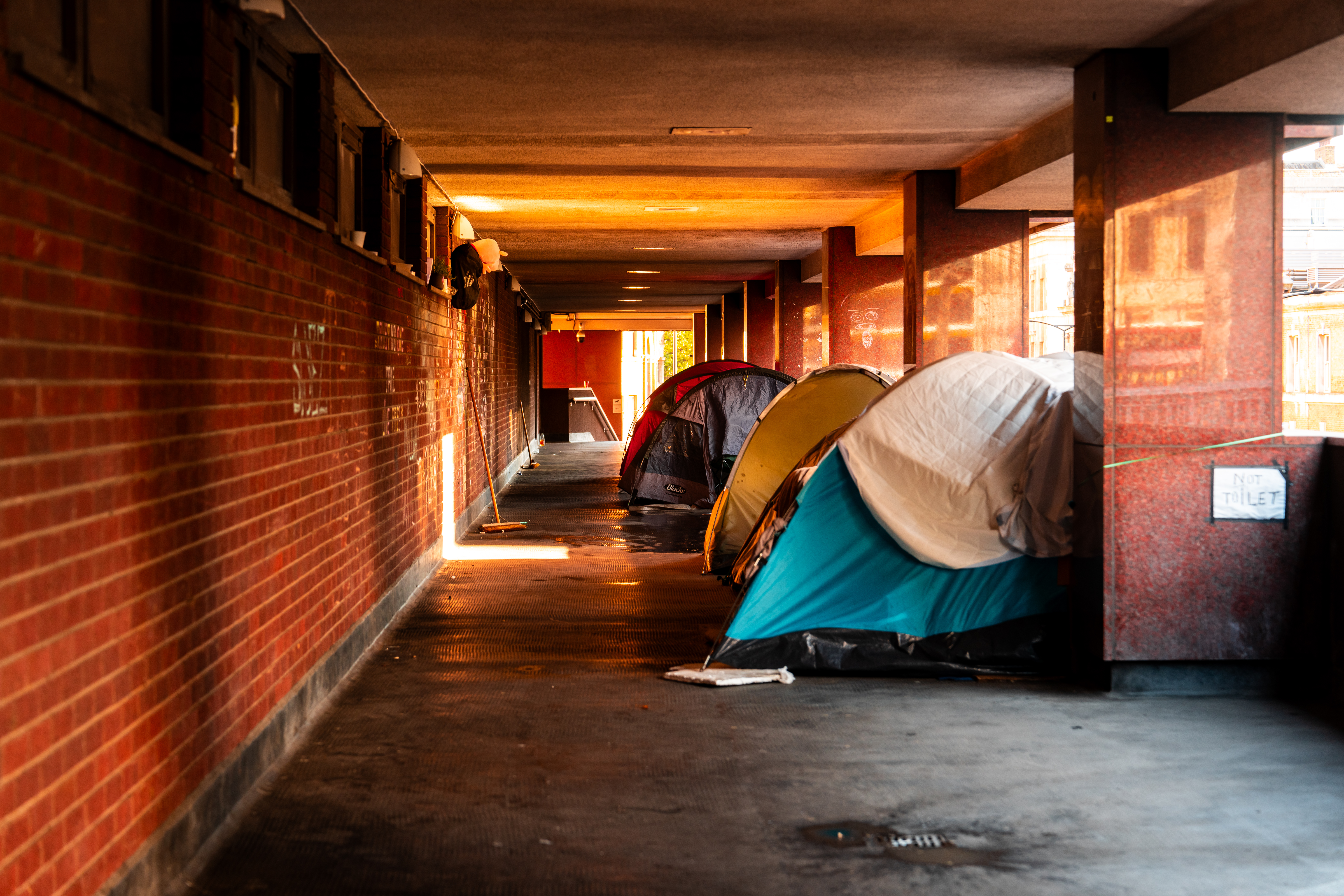 Passage under the residence with row of homeless peoples tents - Europe Confronts Rising Homelessness Crisis - hero image
