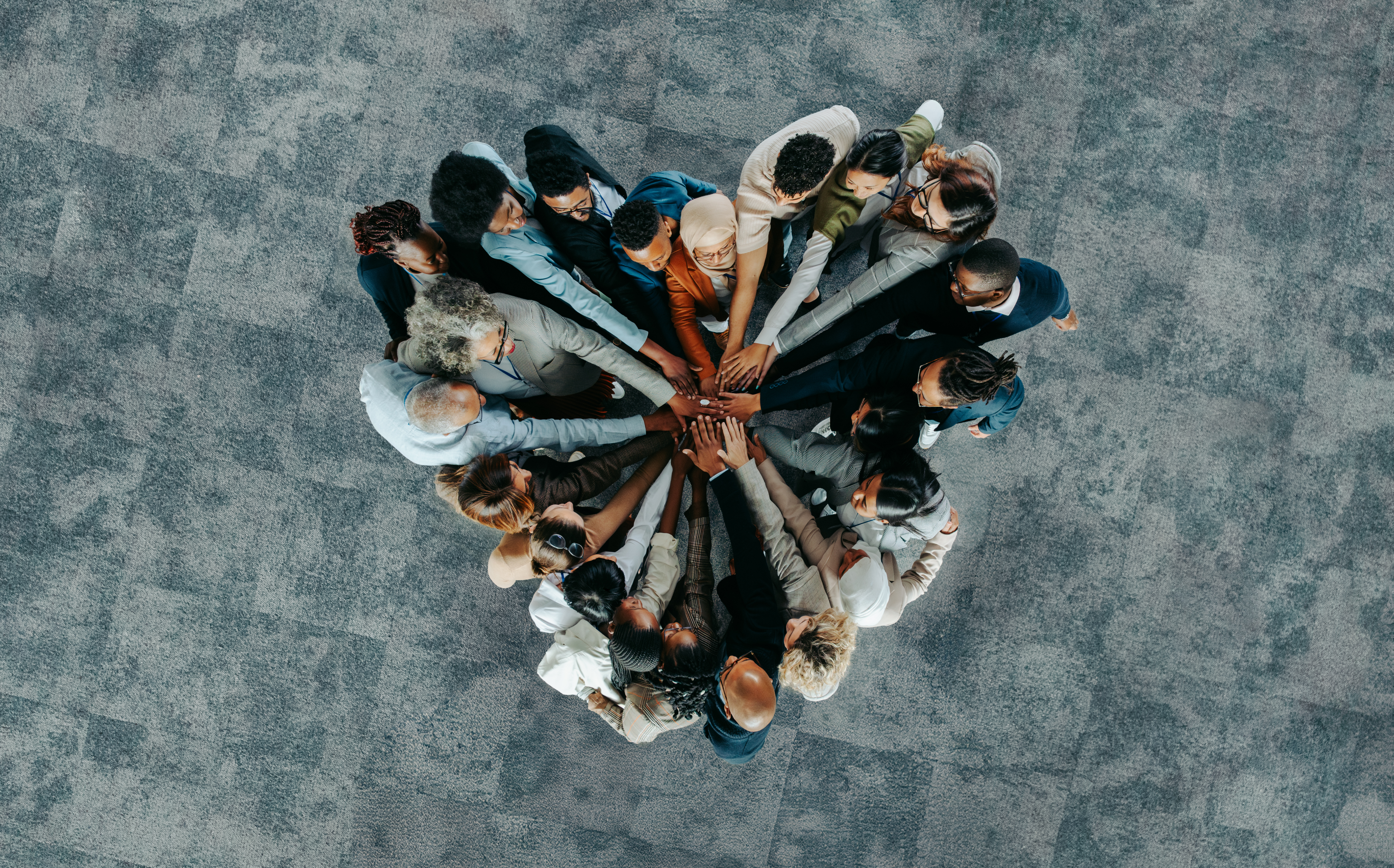 multicultural group of people holding their hands together