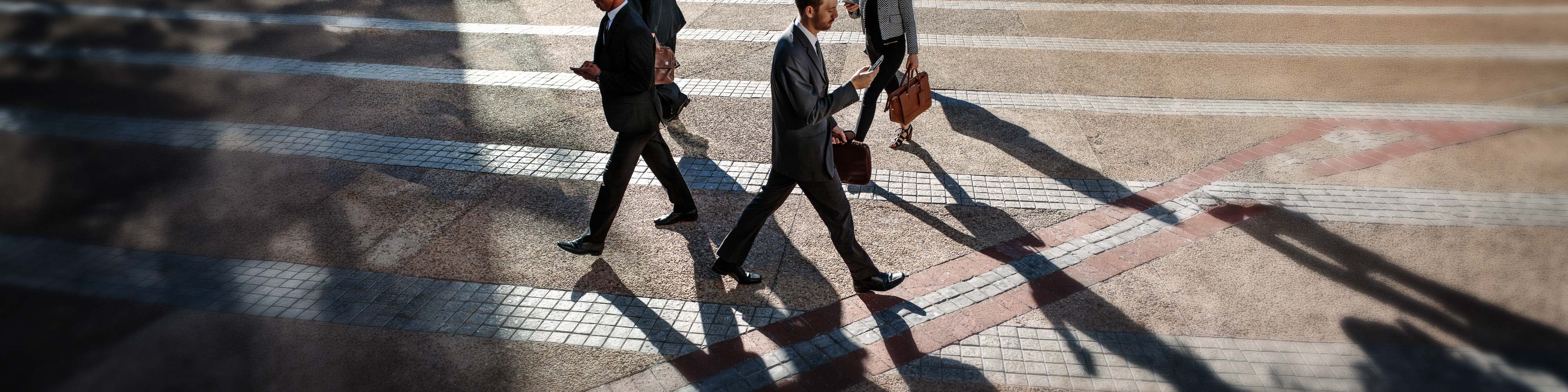 Business people walking across a textured plaza
